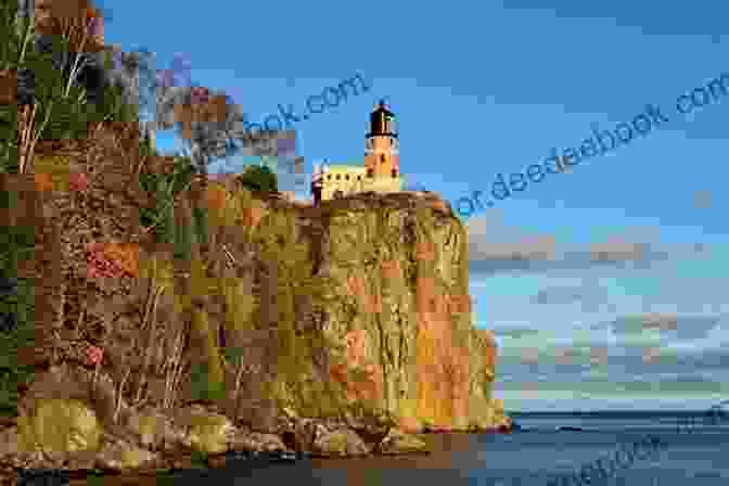 Split Rock Lighthouse, Minnesota, Sits On A Rocky Cliff Overlooking Lake Superior. The Lighthouse's Red Sandstone Exterior Contrasts With The Blue Green Waters And Lush Vegetation. 60 Lighthouses: Photographs By Kevin Woyce